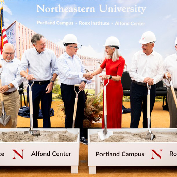 Northeastern President Joseph E. Aoun shakes hands with Barbara Roux during the groundbreaking ceremony for the university’s new Portland campus.